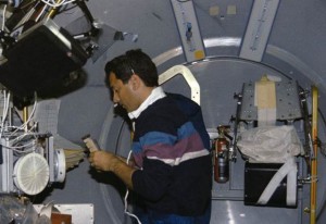 Astronaut Larry DeLucas, payload specialist, handles a Protein Crystal Growth (PCG) sample at the multipurpose glovebox aboard the Earth-orbiting space shuttle Columbia. (NASA)