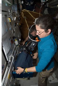 NASA astronaut Nicole Stott, STS-133 mission specialist, using a camcorder to record Mouse Immunology-2 investigation in one of the space shuttle Discovery’s middeck lockers. (NASA)