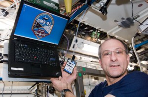 View of Don Pettit, Expedition 30 Flight Engineer, holding the Alpha Magnetic Spectrometer (AMS) laptop in the U.S. Laboratory of the International Space Station. (NASA)