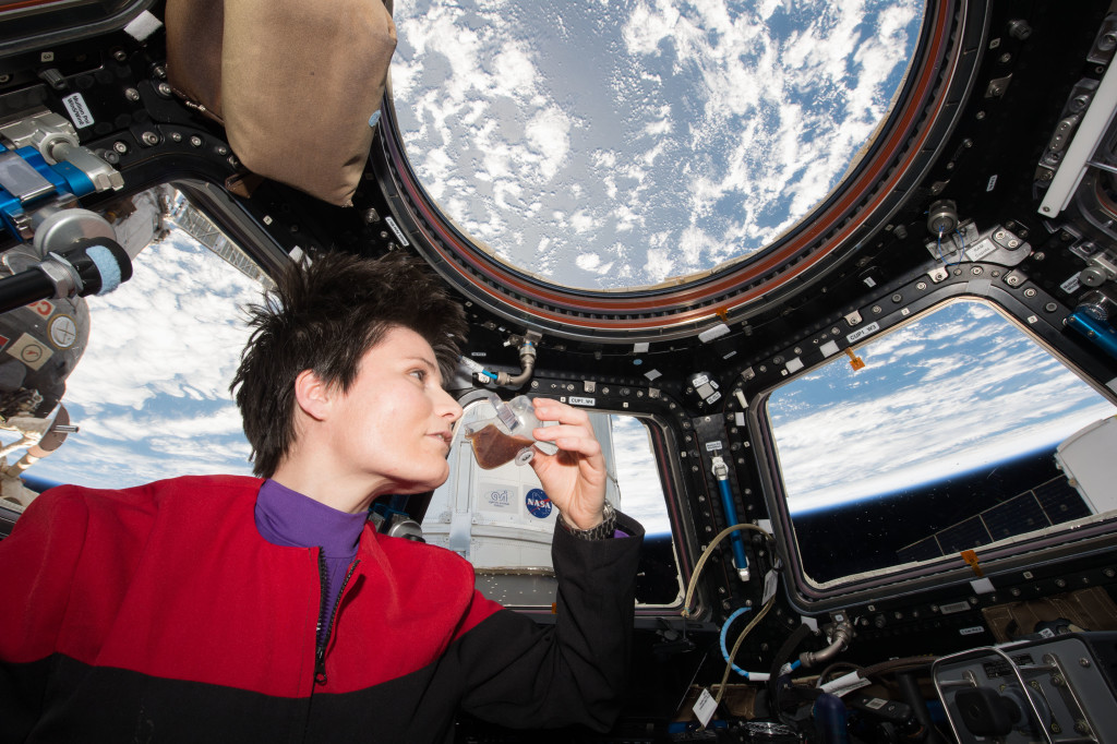 SA (European Space Agency) astronaut Samantha Cristoforetti - dressed in a Star Trek Voyager uniform - takes a sip of espresso from the new Capillary Beverage investigation, also known as Space Cup while looking out of the Cupola window.