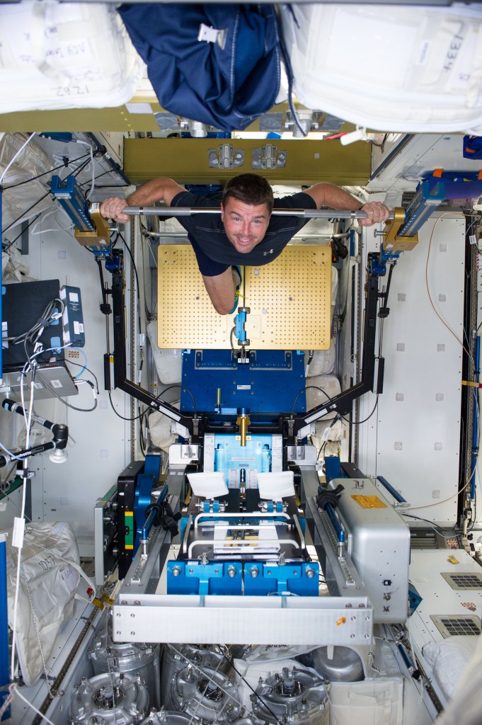 NASA astronaut Reid Wiseman, Expedition 40 flight engineer, gets a workout on the Advanced Resistive Exercise Device (ARED) in the Tranquility node of the International Space Station. (NASA)