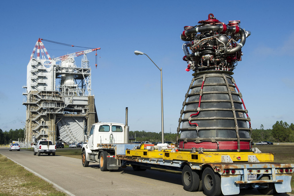 An RS-25 engine is delivered by flatbed truck to a test stand at Stennis Space Center.