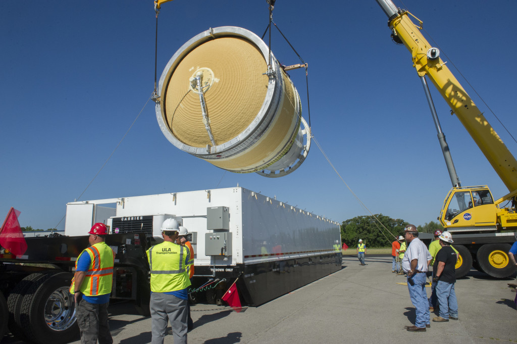 A crane lifts the ICPS test article out of a shipping container.