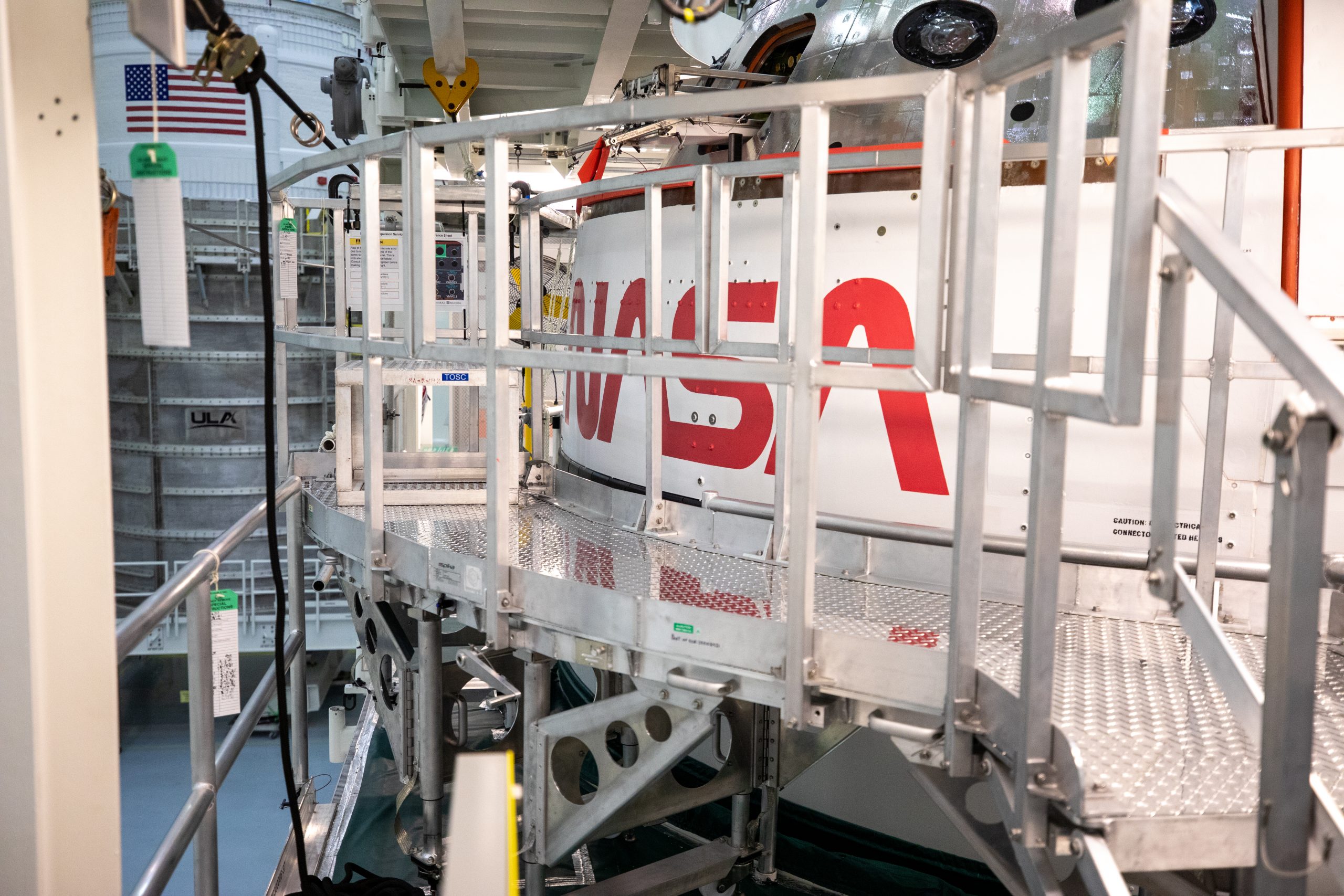 The historic worm logo is visible on the Orion spacecraft's crew module adapter inside the Multi-Payload Processing Facility.