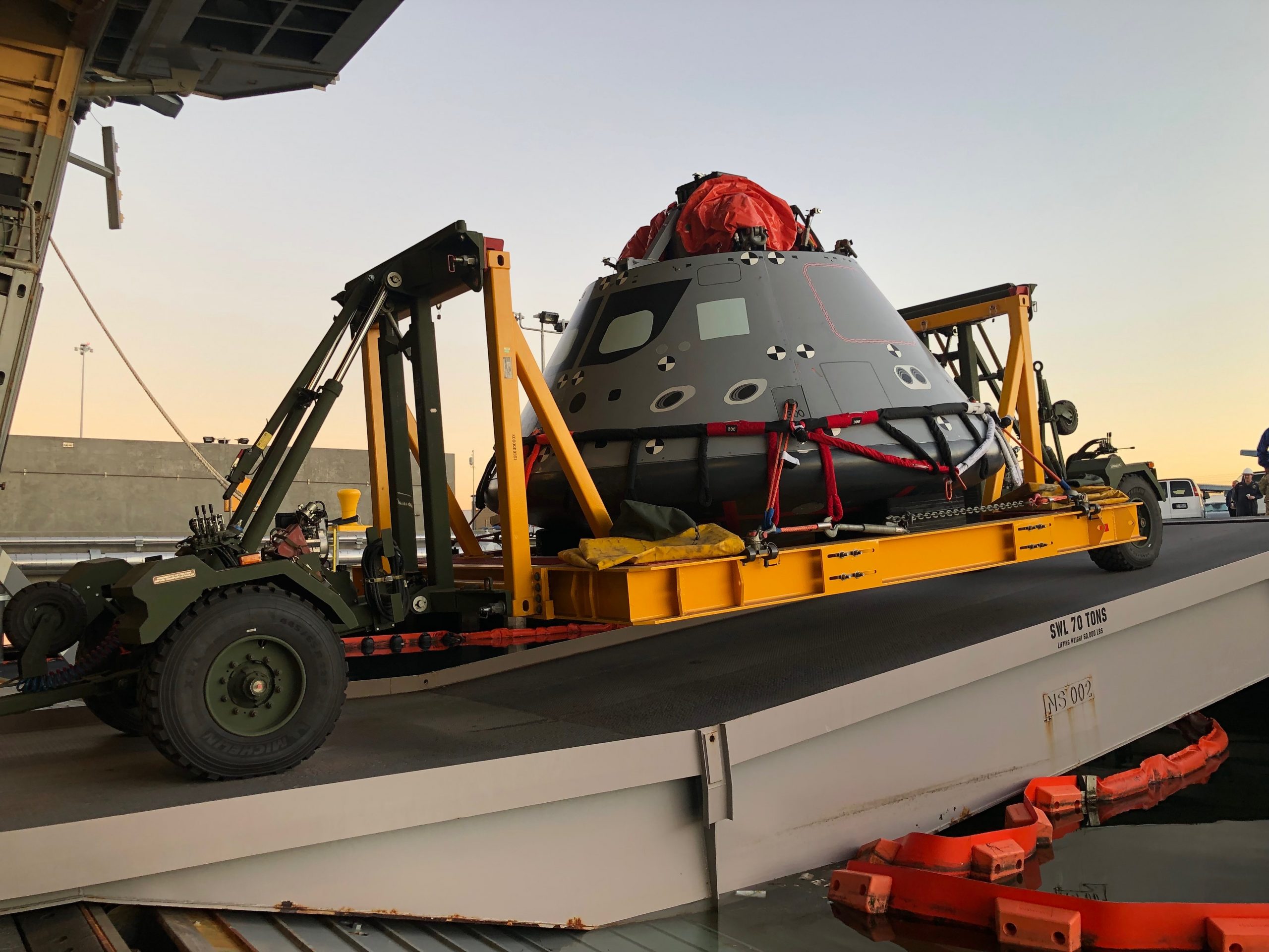 A test version of the Orion spacecraft is loaded into the well deck of a U.S. Navy ship.