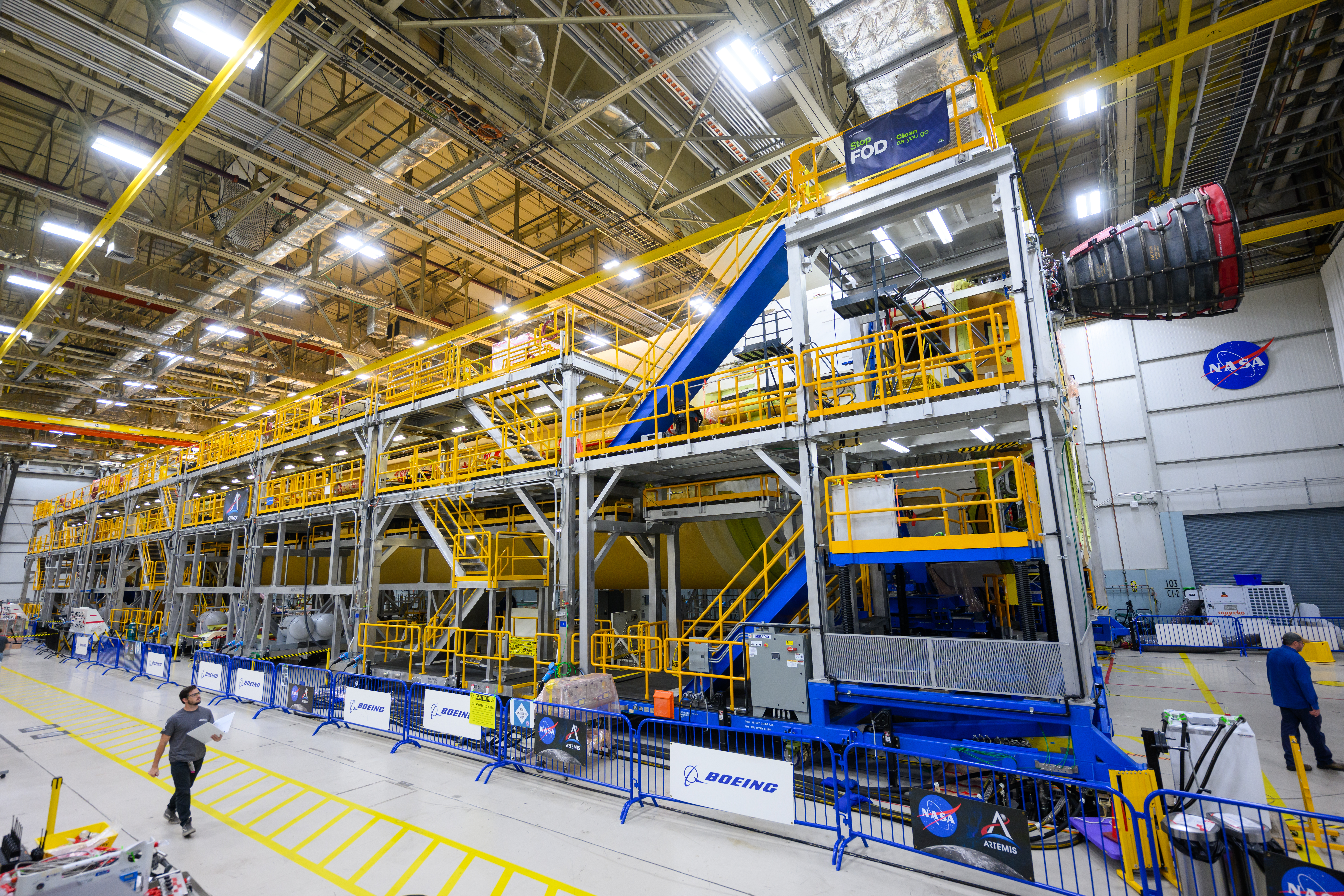 Engineers and technicians from Aerojet Rocketdyne and Boeing at NASA’s Michoud Assembly Facility in New Orleans have installed the first of four RS-25 engines to the core stage for NASA’s Space Launch System rocket that will help power the first crewed Artemis mission to the Moon. The yellow core stage is seen in a horizontal position in the final assembly area at Michoud. One RS-25 engine, engine number E2059, has been installed in the top left corner at the base of the 212-foot-tall core stage.