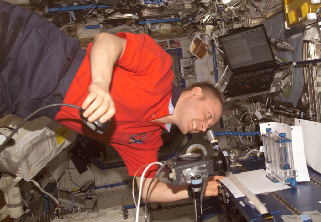 Astronaut Edward M. (Mike) Fincke, Expedition 9 NASA ISS science officer and flight engineer, performs one of multiple tests of the Capillary Flow Experiment investigation in the Destiny laboratory of the International Space Station in September 2004.