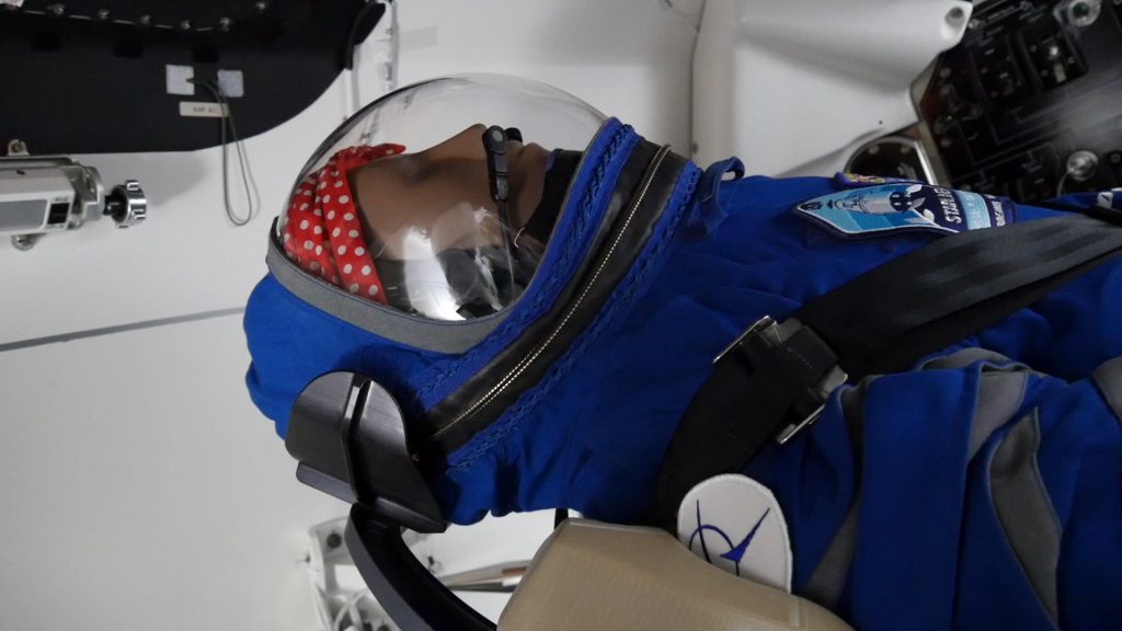 An anthropometric test device, called Rosie, is in view inside Boeing's CST-100 Starliner spacecraft. Rosie will fly aboard Starliner on the company's Orbital Flight Test, an inaugural flight to the International Space Station as part of NASA's Commercial Crew Program.