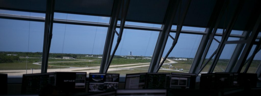 A SpaceX Falcon 9 rocket with the company's Crew Dragon spacecraft onboard is seen at Launch Complex 39A through the windows of Firing Room Four of Kennedy's Launch Control Center during a dress rehearsal on May 23, 2020, in preparation for the launch of NASA’s SpaceX Demo-2 mission.