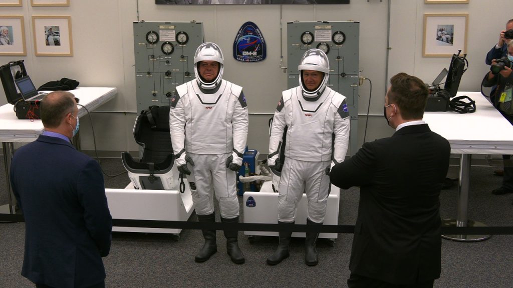 NASA astronauts Robert Behnken, left, and Douglas Hurley talk to NASA Administrator Jim Bridenstine, far left, and SpaceX's Elon Musk inside the suit room in Kennedy Space Center's Neil Armstrong Operations and Checkout Building.