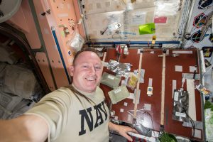 Commander Barry Wilmore takes a self-portrait with food packages (smoked turkey, cranapple dessert, cornbread dressing, and tea with sugar) planned for his Thanksgiving meal.