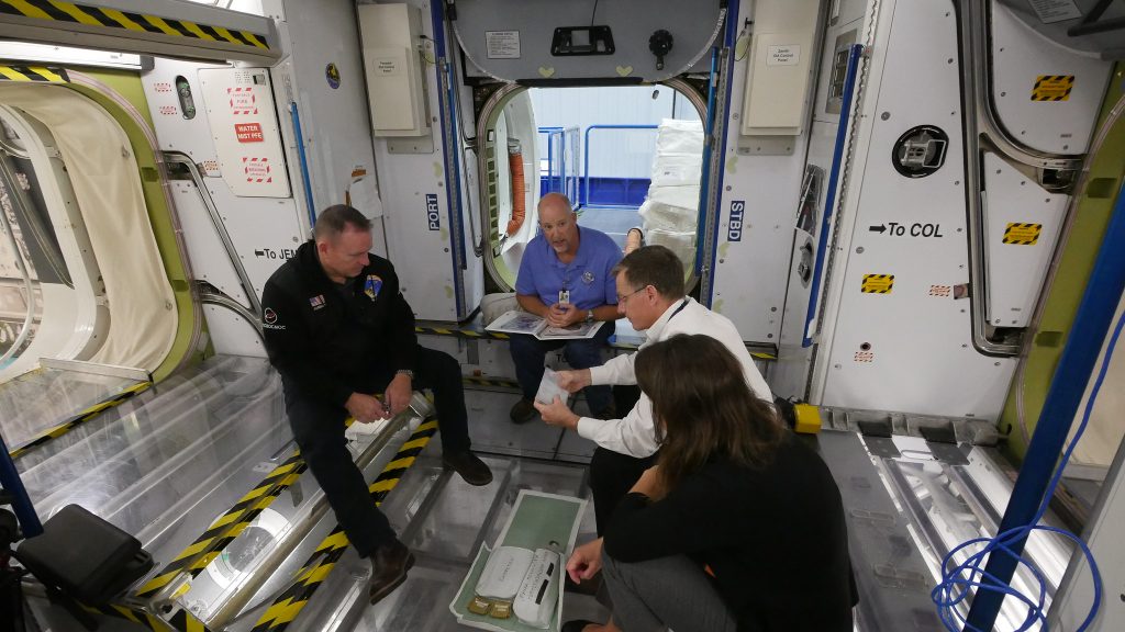 NASA astronauts Nicole Mann and Barry “Butch” Wilmore and Boeing astronaut Chris Ferguson review International Space Station training at NASA’s Johnson Space Center in Houston, Texas.