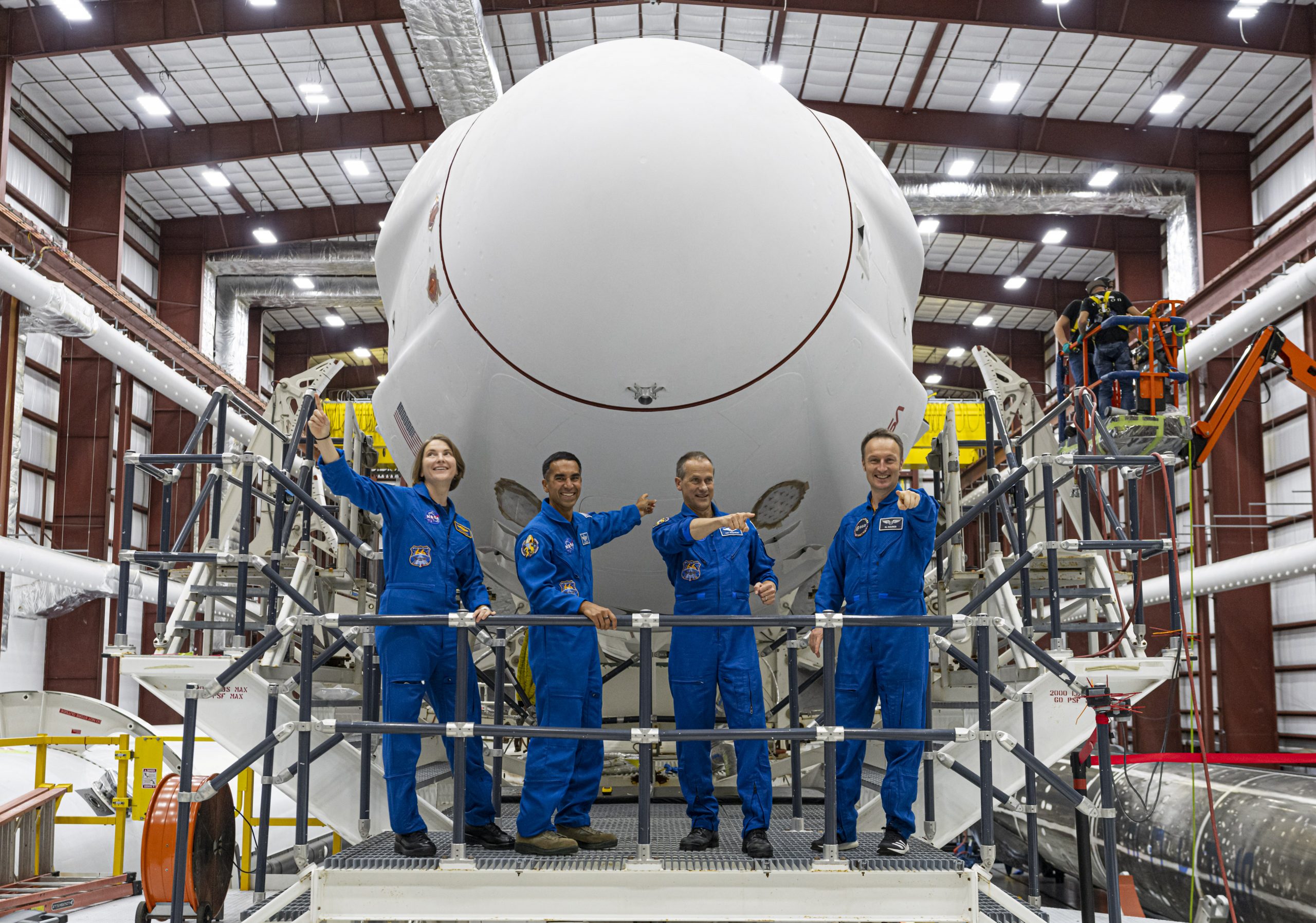 The astronauts for NASA's SpaceX Crew-3 mission are photographed in front of the Falcon 9 rocket inside the hangar at Kennedy Space Center's Launch Complex 39A in Florida.