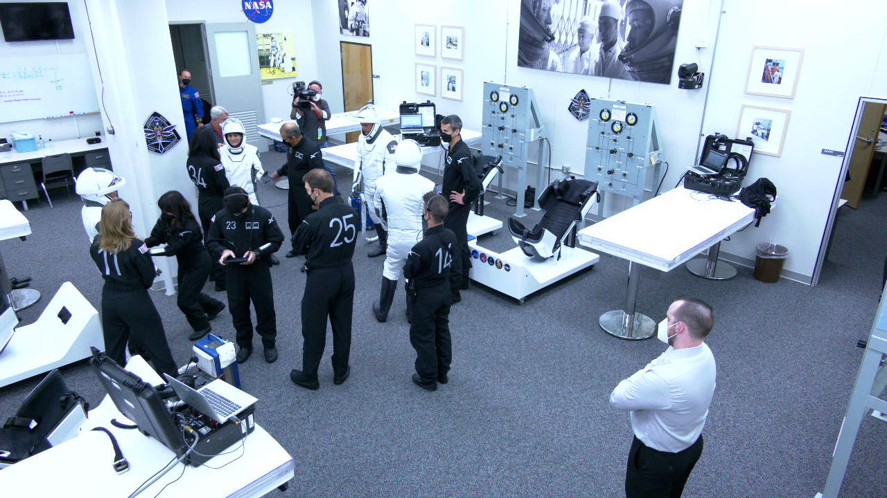 NASA SpaceX Crew-4 mission astronauts are in the suit-up room in the Astronaut Crew Quarters inside Kennedy Space Center’s Neil A. Armstrong Operations and Checkout Building on April 27, 2022. A team of SpaceX suit technicians are helping them as they put on their custom-fitted spacesuits and check the suits for leaks. Photo credit: NASA