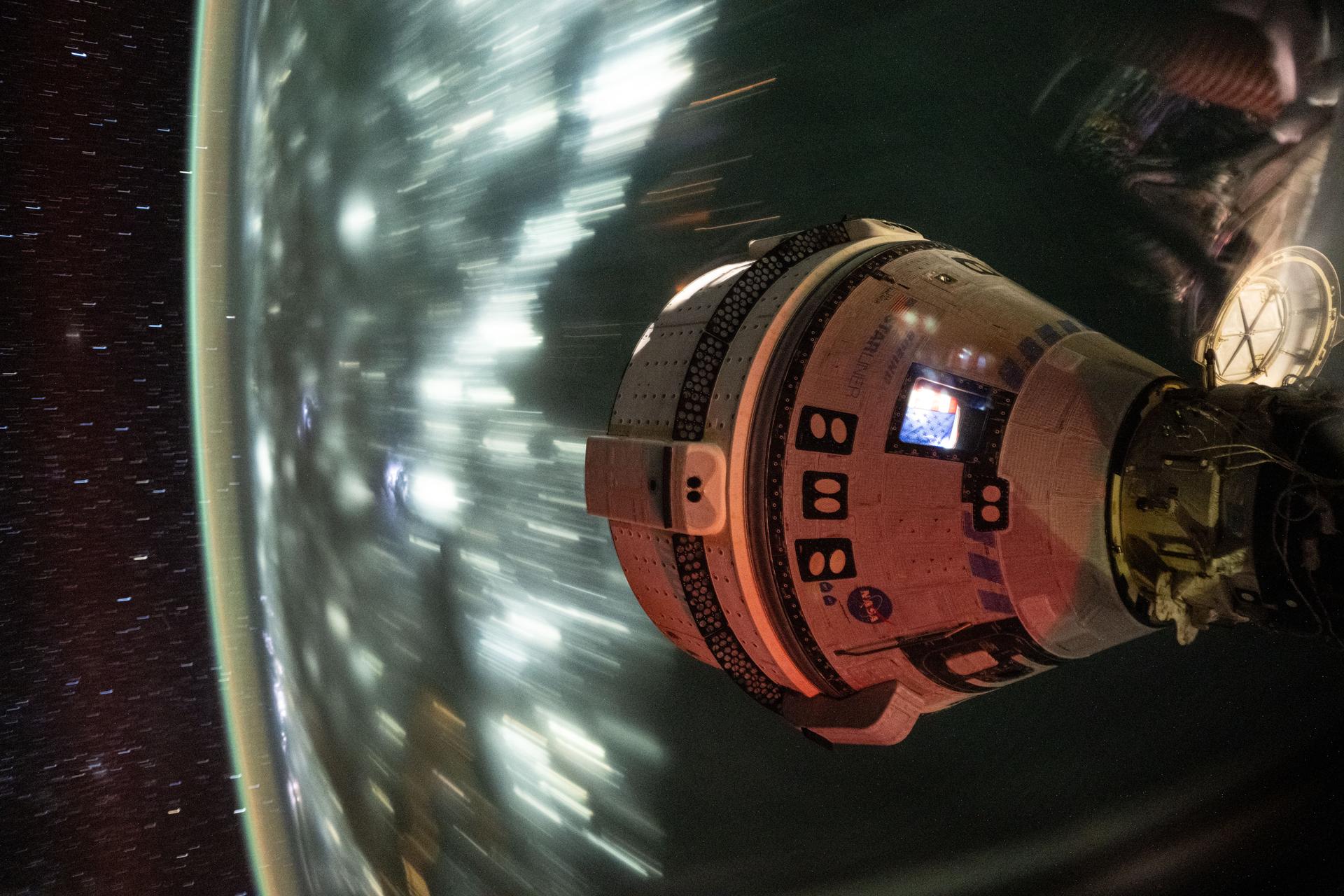 Boeing's Starliner spacecraft that launched NASA's Crew Flight Test astronauts Butch Wilmore and Suni Williams to the International Space Station is pictured docked to the Harmony module's forward port. This long-duration photograph was taken at night from the orbital complex as it soared 256 miles above the Arabian Sea off the coast of Mumbai, India.