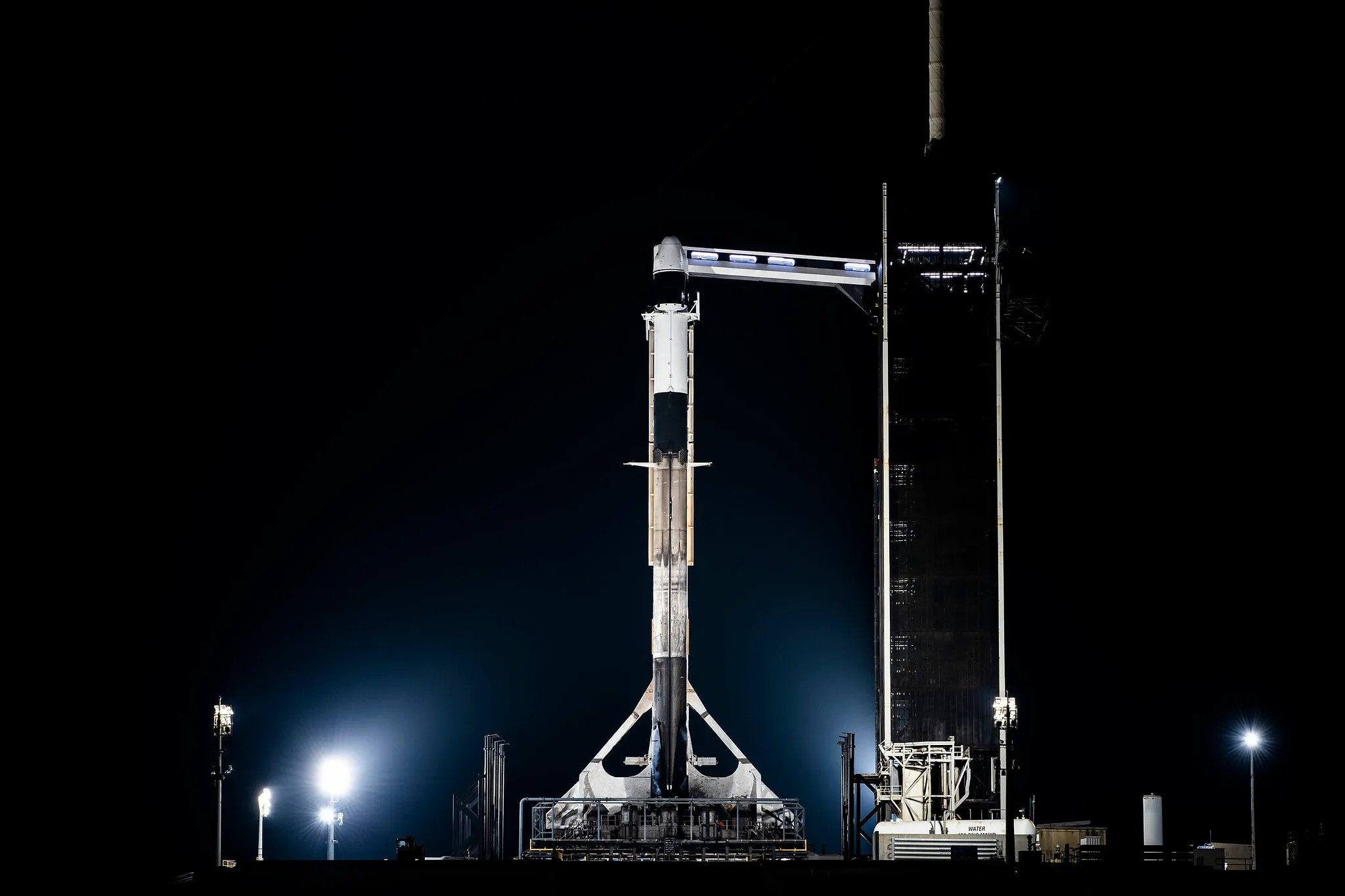 Image shows a Falcon 9 rocket carrying a Dragon spacecraft before it launches to the International Space Station.