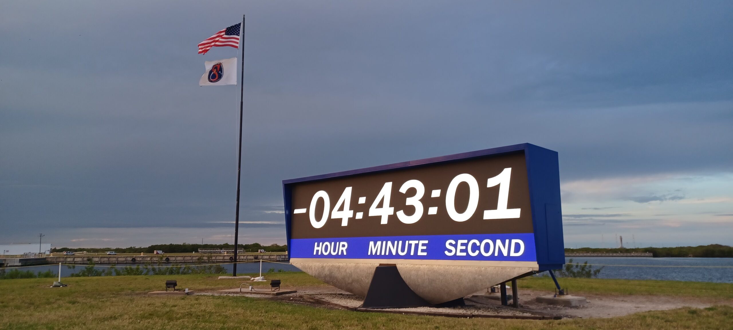 The Crew-8 and American flags fly over the iconic countdown clock near the NASA News Center at the agency's Kennedy Space Center in Florida ahead of NASA's SpaceX Crew-8 launch, Sunday, March 3, 2024.