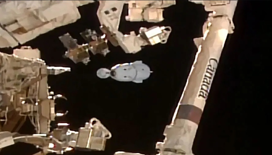 The SpaceX Dragon Endeavour spacecraft is pictured beyond the Candarm2 robotic arm moments after undocking from the Harmony module with four Crew-8 members.