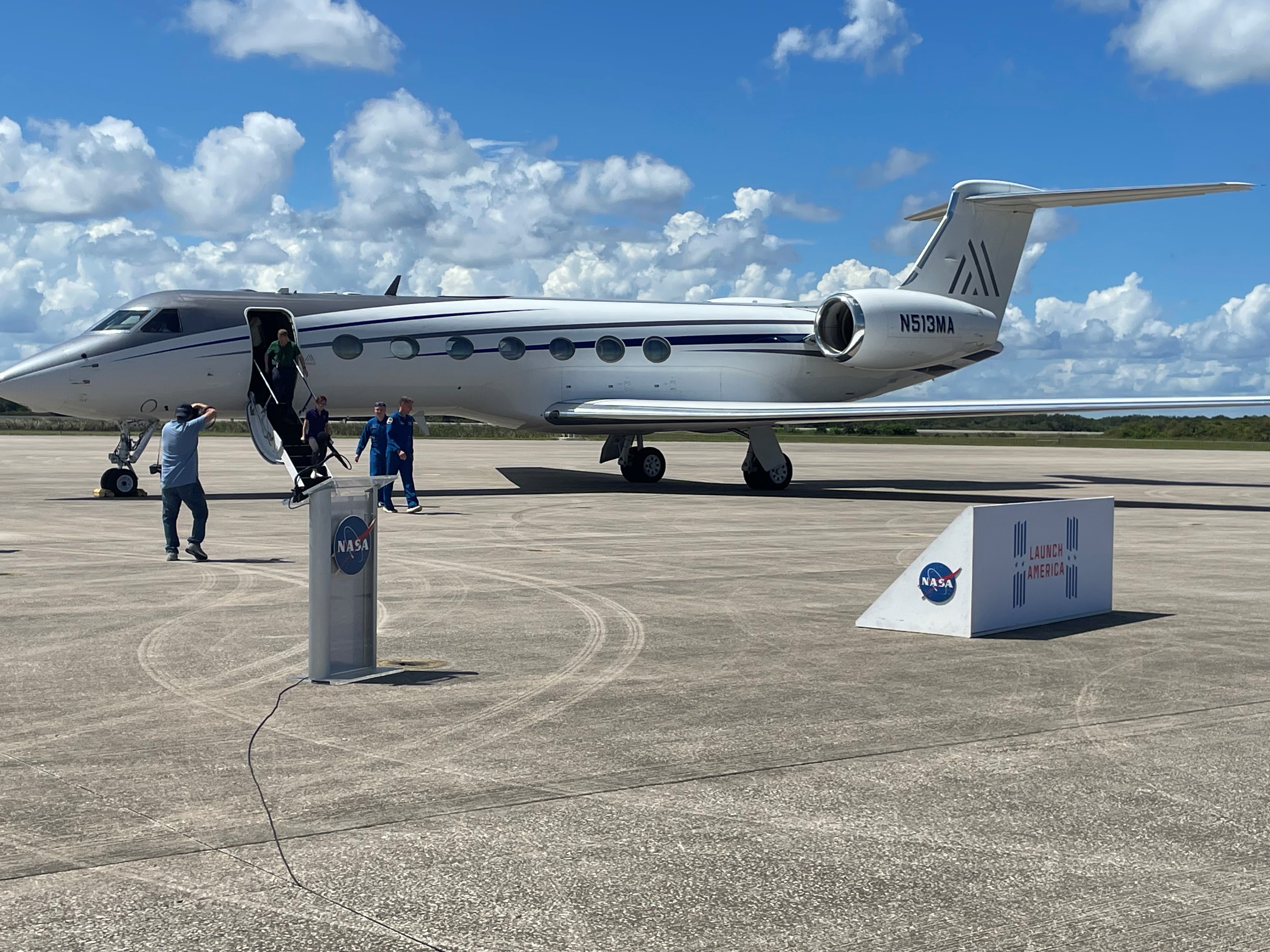 NASA astronaut Nick Hague and Roscosmos cosmonaut Aleksandr Gorbunov in blue flight suits deplane from a Gulfstream jet