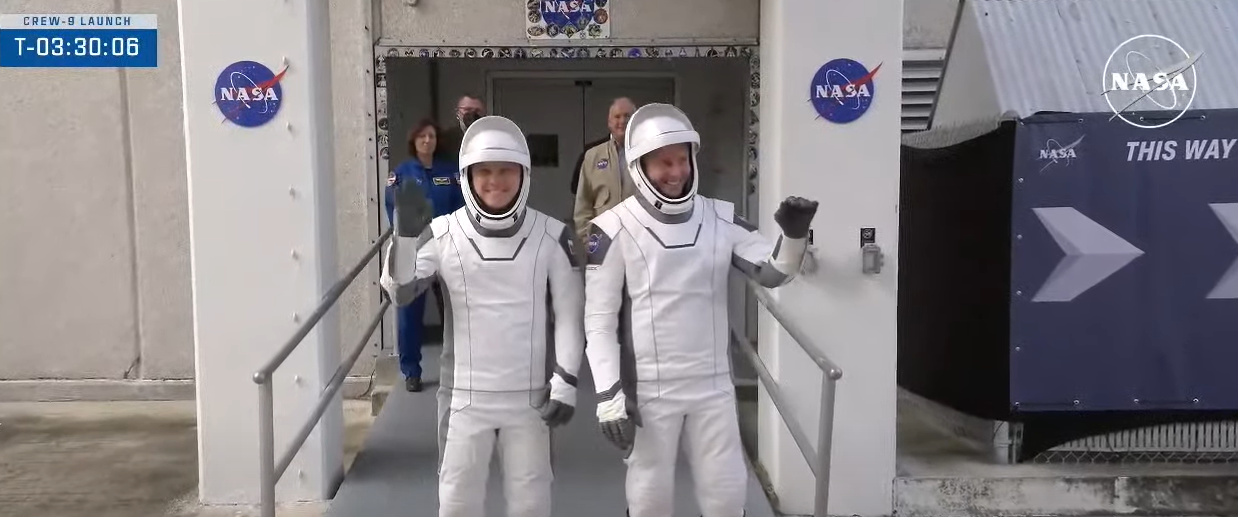 Image shows NASA's SpaceX Crew-9 crew members walk out of the Neil A. Armstrong Operations and Checkout Building at NASA's Kennedy Space Center on Saturday, Sept. 28, 2024.