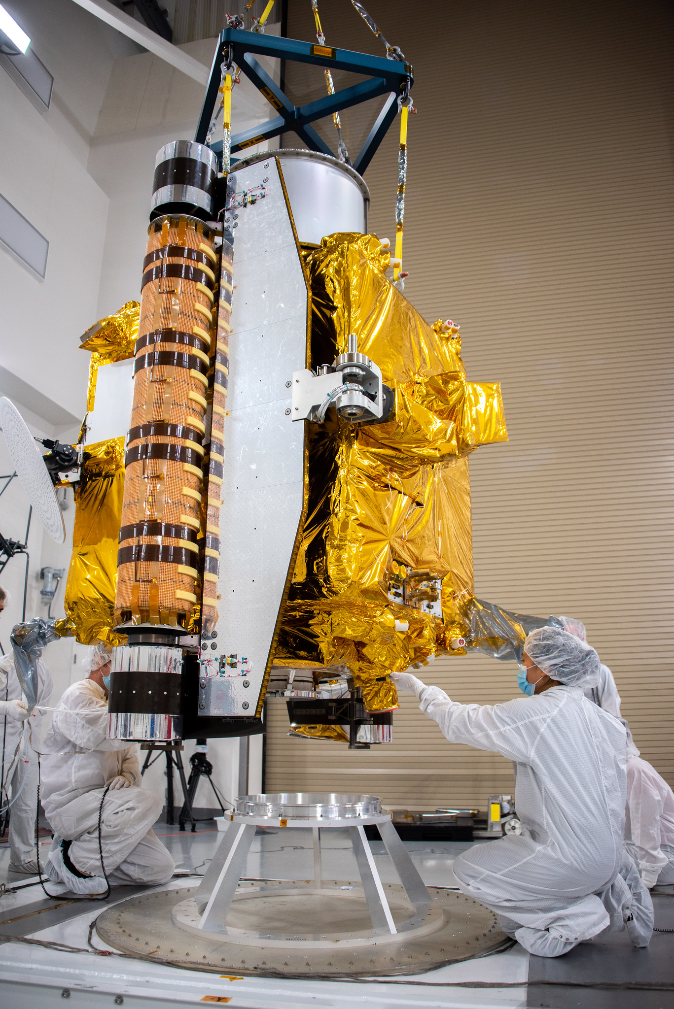 Technicians lower NASA's Double Asteroid Redirection Test (DART) spacecraft onto a work stand inside the Astrotech Space Operations Facility at Vandenberg Space Force Base in California on Oct. 4, 2021. The mission is targeted to launch on Nov. 23, 2021, aboard a SpaceX Falcon 9 rocket from Vandenberg. 