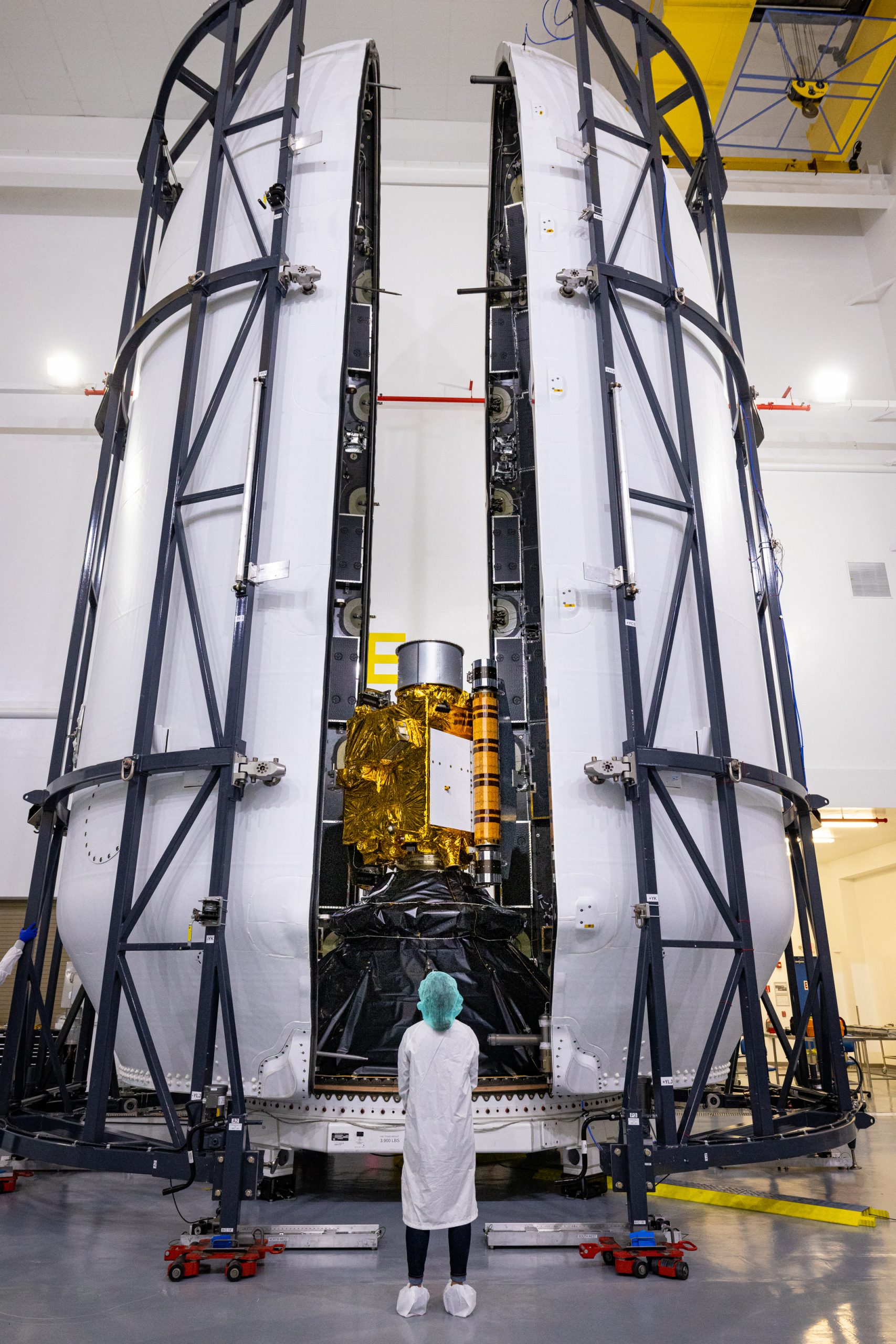 Inside SpaceX’s Payload Processing Facility at Vandenberg Space Force Base in California, both halves of the Falcon 9 rocket’s protective payload fairing move toward NASA’s Double Asteroid Redirection Test (DART) spacecraft on Nov. 16, 2021. The payload fairing, with the spacecraft securely inside, will be attached to the top of the Falcon 9 and will protect the spacecraft during launch and ascent.