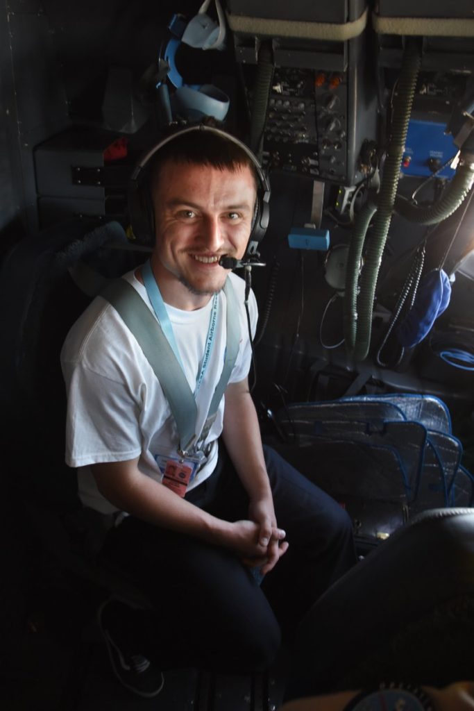 Corey Walker sits in the cockpit jump seat aboard the NASA DC-8 during a science flight. Credits: NASA / Megan Schill