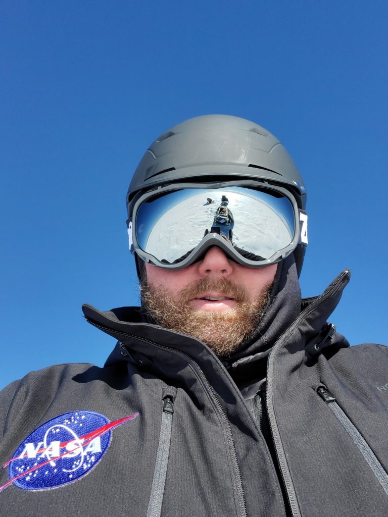 SnowEx 2020 operations manager Jerry Newlin (ATA Aerospace) caught Chris Hiemstra (U.S. Army Corps of Engineers’ Cold Regions Research and Engineering Laboratory) in the reflection of his goggles during one of their daily snowmobile commutes. "It looks like Chris is collecting data on the Moon," Newlin said. Credit: NASA / Jerry Newlin