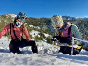 The author and another research assistant, Megan Mason, identify snow crystal types in an early-season snow pit at Copper Mountain, Idaho, December 2020. Credit: G. Antonioli