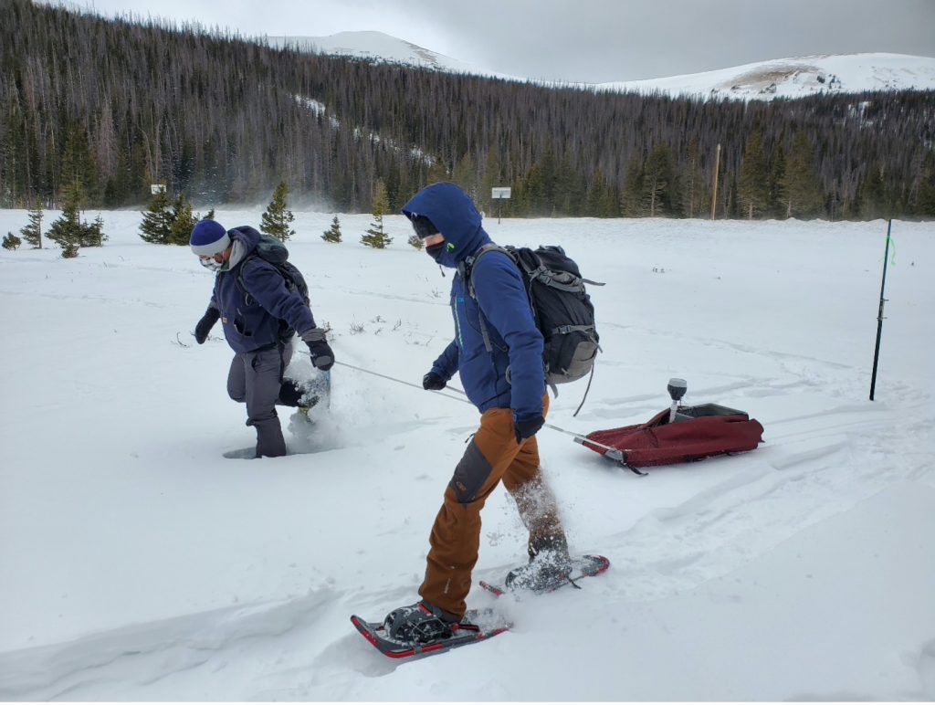 Two scientists trek through the snow to a site in Cameron Pass, Colorado.