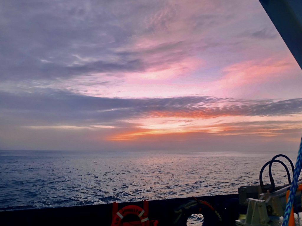 A pink and purple sunrise over the ocean.