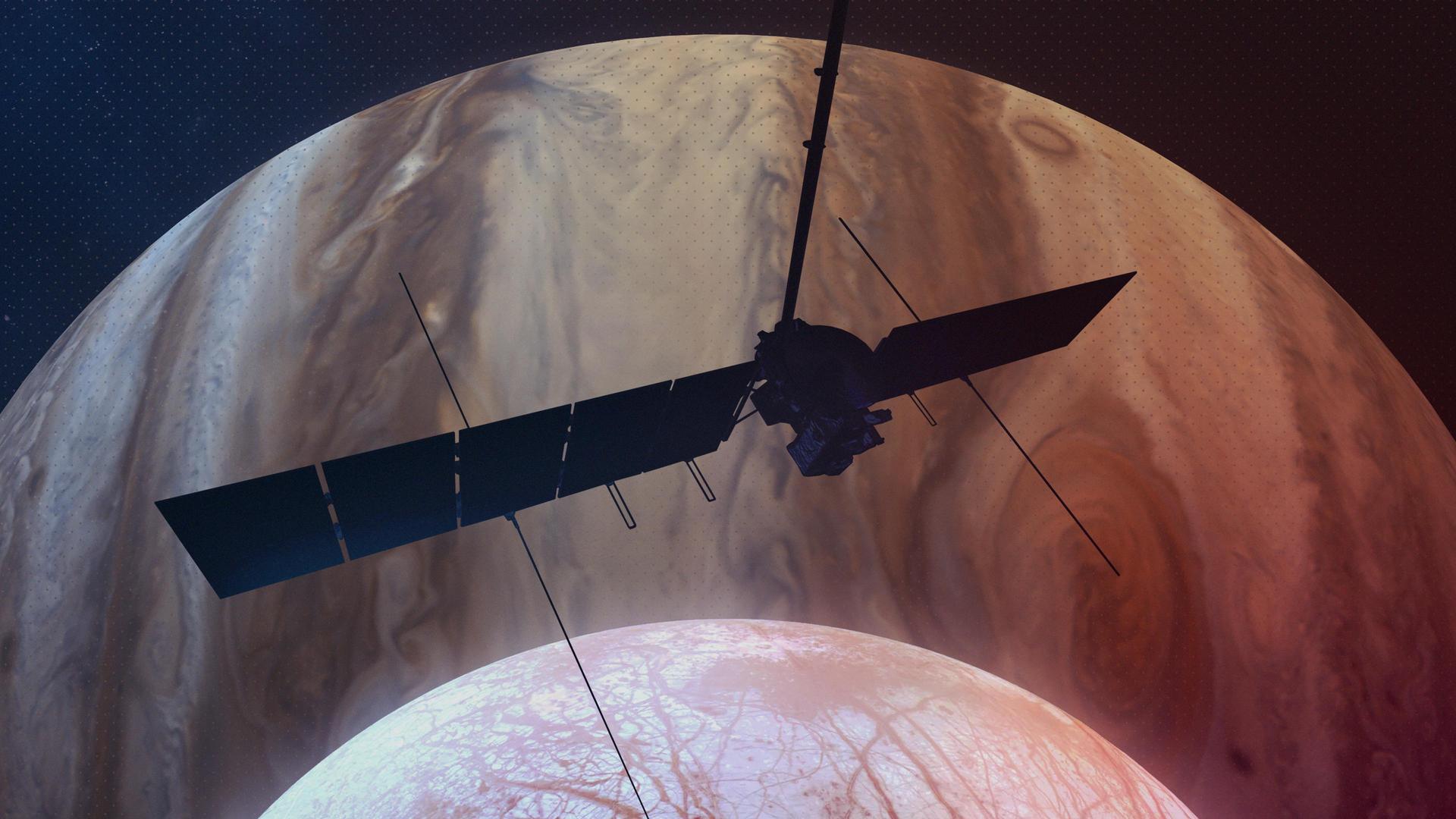 This artist's concept depicts NASA's Europa Clipper spacecraft silhouetted against Jupiter as it passes over the gas giant's icy moon Europa (bottom center). Scheduled to orbit Jupiter beginning in April 2030, the mission will be the first to specifically target Europa for detailed science investigation.