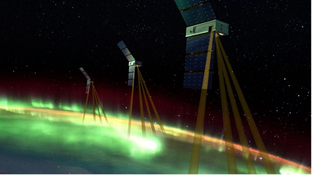 Three EZIE spacecraft above an aurora over Earth