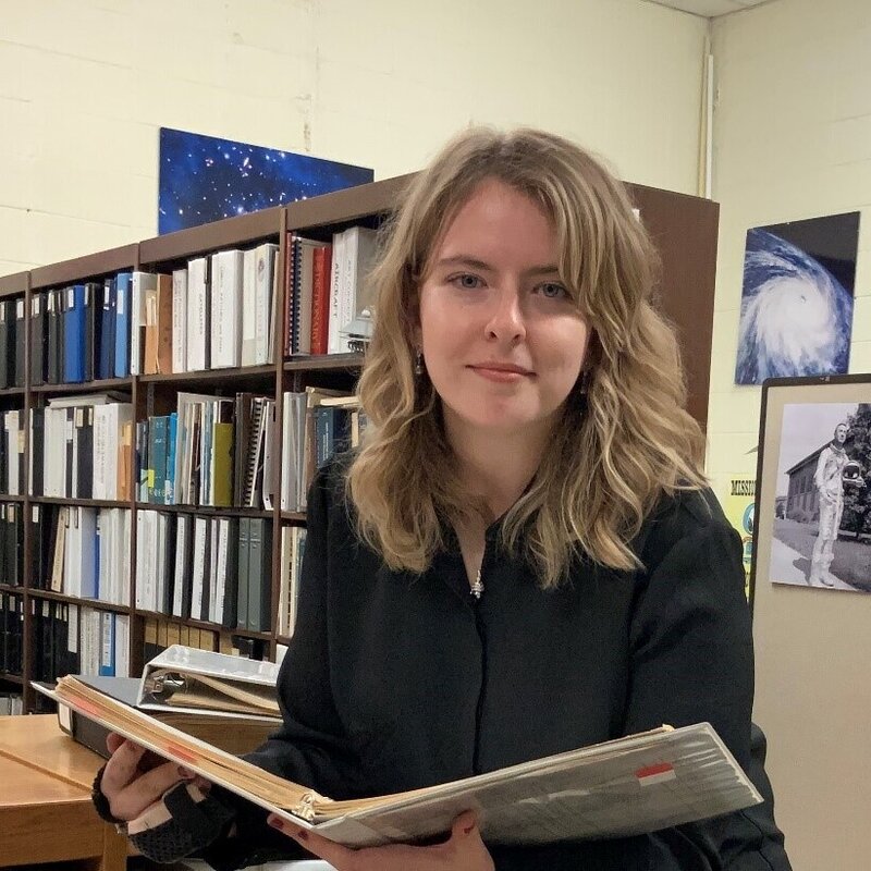 Caption: Jessica Bardetsky holding a logbook as part of her internship project. Credit: Jessica Bardetsky