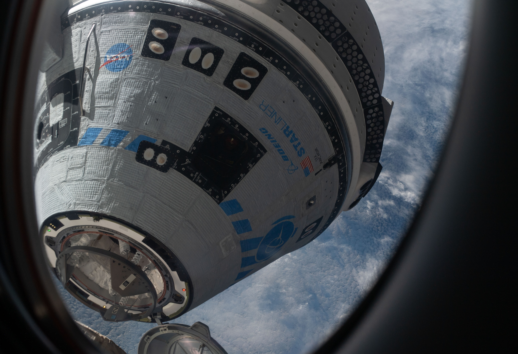 View from a window on the SpaceX Crew Dragon Freedom crew ship shows Boeing's CST-100 Starliner crew ship moments away from docking to the Harmony module's forward port on the International Space Station for the company's Orbital Flight Test-2 mission. (NASA Johnson Space Center). 