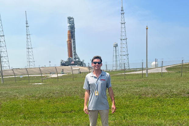 A former NASA intern from the Kennedy Space Center in Florida standing in front of the Space Launch System Rocket (SLS) for the Artemis I missions.