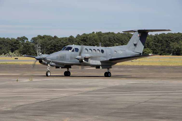 A gray aircraft taxis on the runway.