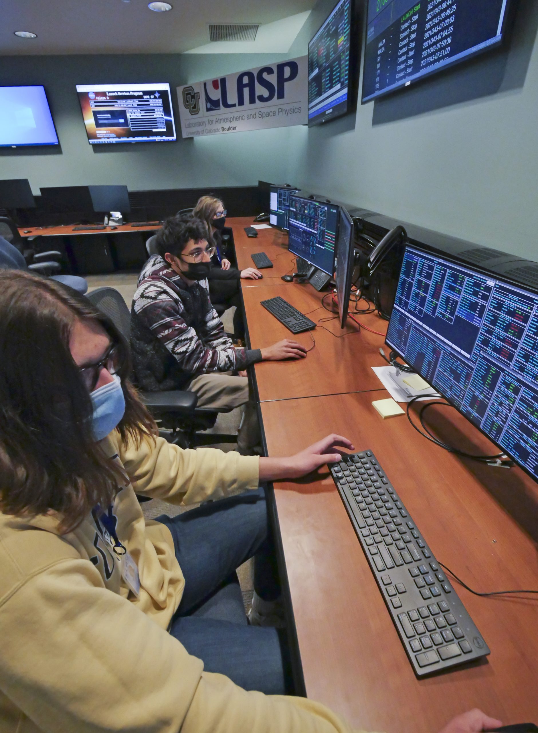 College students sit as computers lined in a row to work on IXPE.