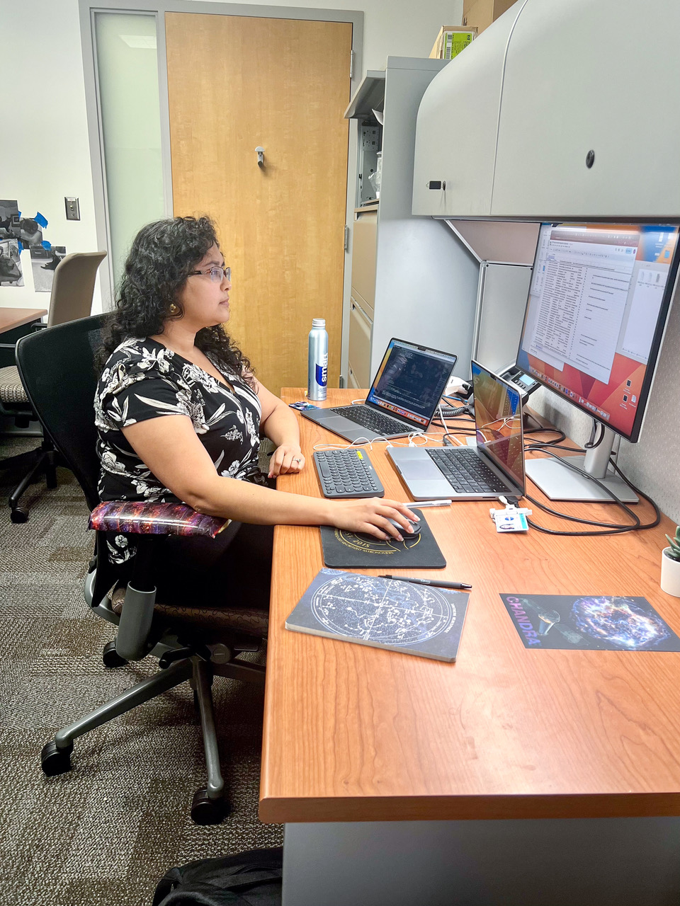 Kavitha Arur sits at her desk and works on the computer in her office.