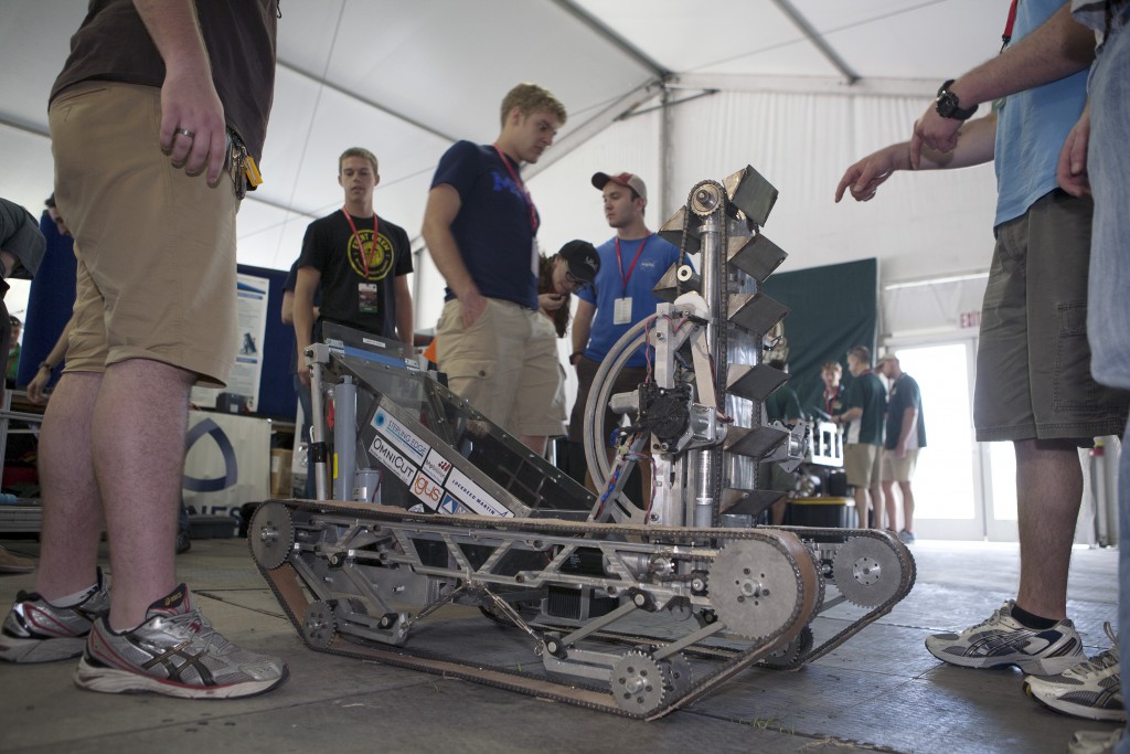 Inside the robot pit preparation facility at NASA's Kennedy Space Center Visitor Complex in Florida, college team members look over their custom-made robot in preparation for NASA's Robotic Mining Competition. 