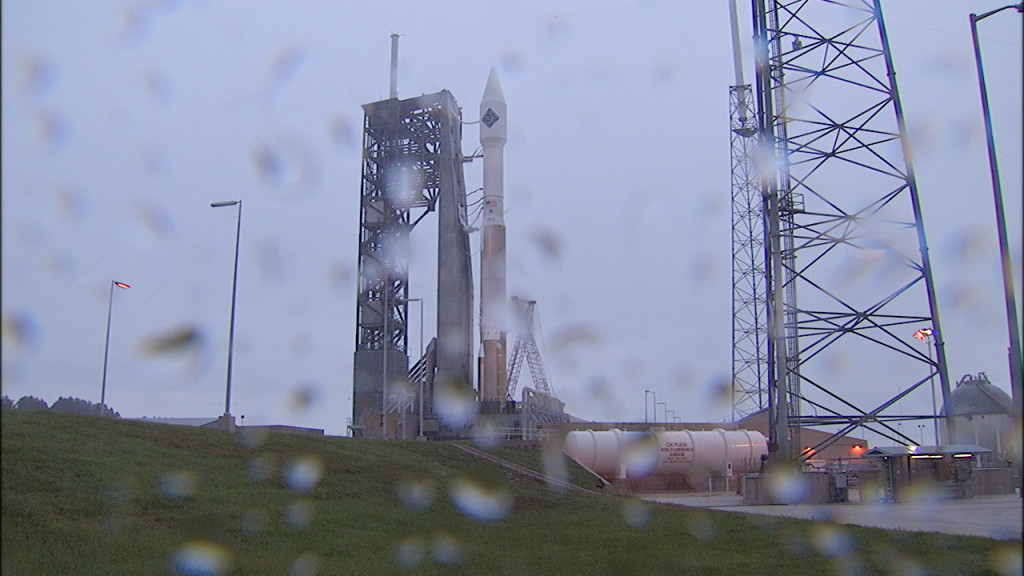 Rain is visible on the camera lens at Space Launch Complex 41 where Atlas V awaits liftoff