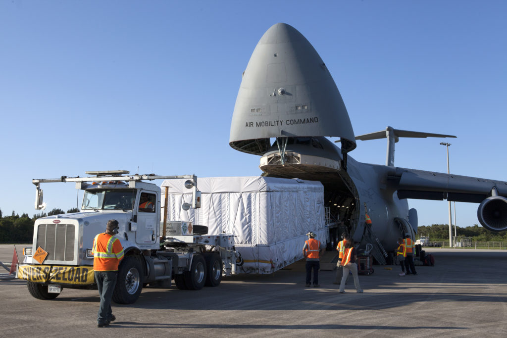 A truck with a specialized transporter drives out of the cargo hold of an Air Force C-5 Galaxy transport plane at the Shuttle Landing Facility at NASA's Kennedy Space Center in Florida to deliver the GOES-R spacecraft for launch processing.