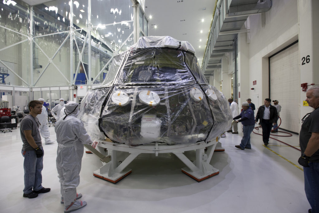 The Orion EM-1 crew module is moved from a clean room to a work station in the O&C Building at Kennedy Space Center.