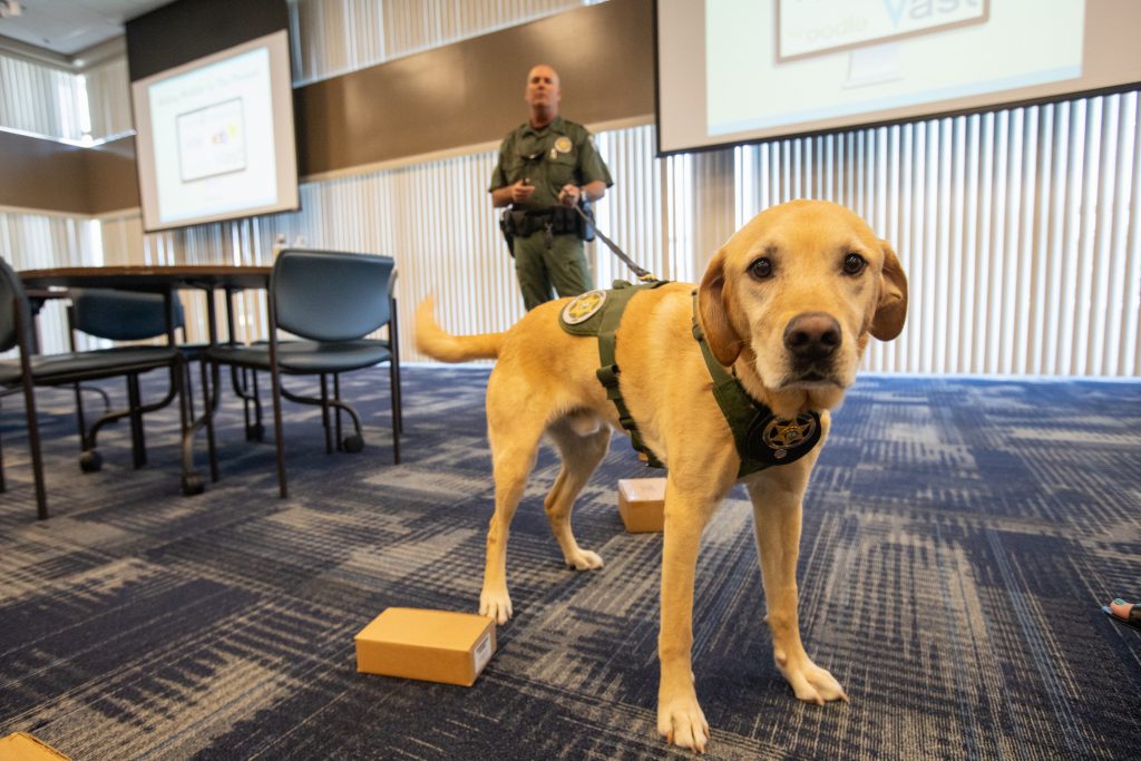 Fish and Wildlife Conservation Commission (FWC) Officer Jeff Sidor presents information on FWC’s Port K9 Program to Kennedy Space Center employees in the Space Station Processing Facility Conference Center on April 23, 2019 with FWC K9 Harry.