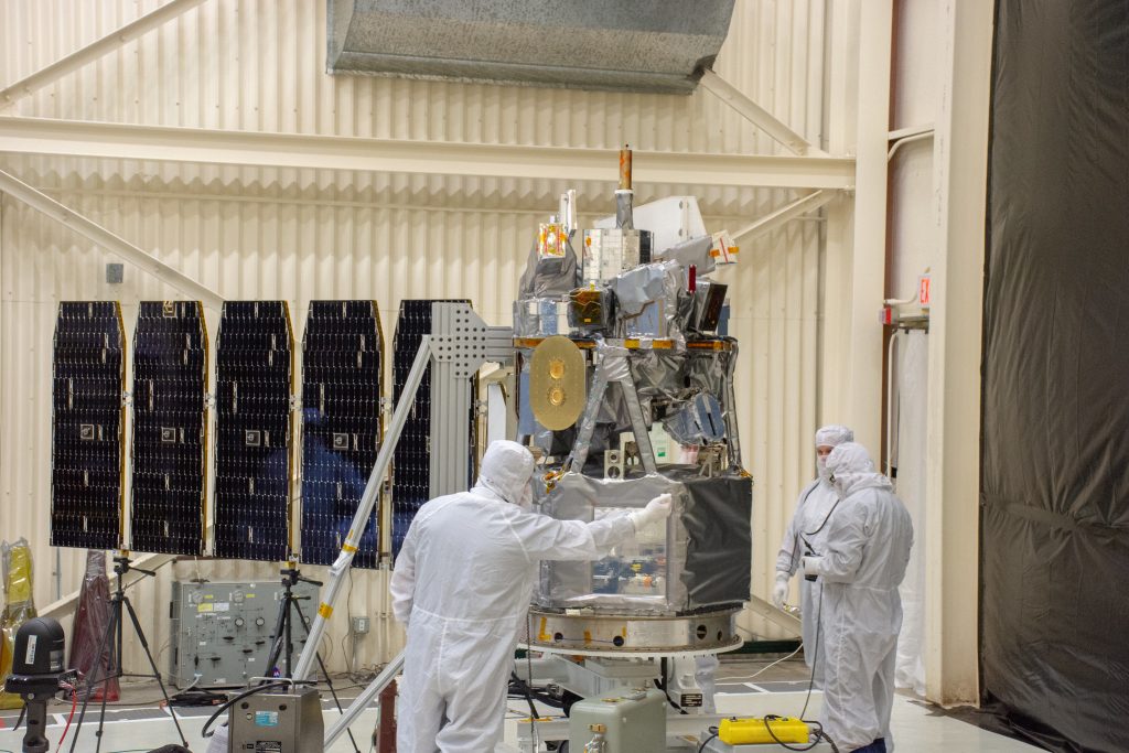 Technicians extend the solar array on NASA's Ionospheric Connection Explorer (ICON) during a deployment test inside Building 1555 at Vandenberg Air Force Base in California on Aug. 10, 2019. 