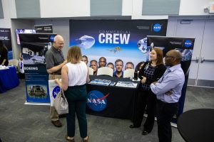 Steve Payne, far left, with NASA’s Commercial Crew Program, visits with a guest during a Community Leaders Update hosted by Kennedy Space Center on Feb. 18, 2020. 