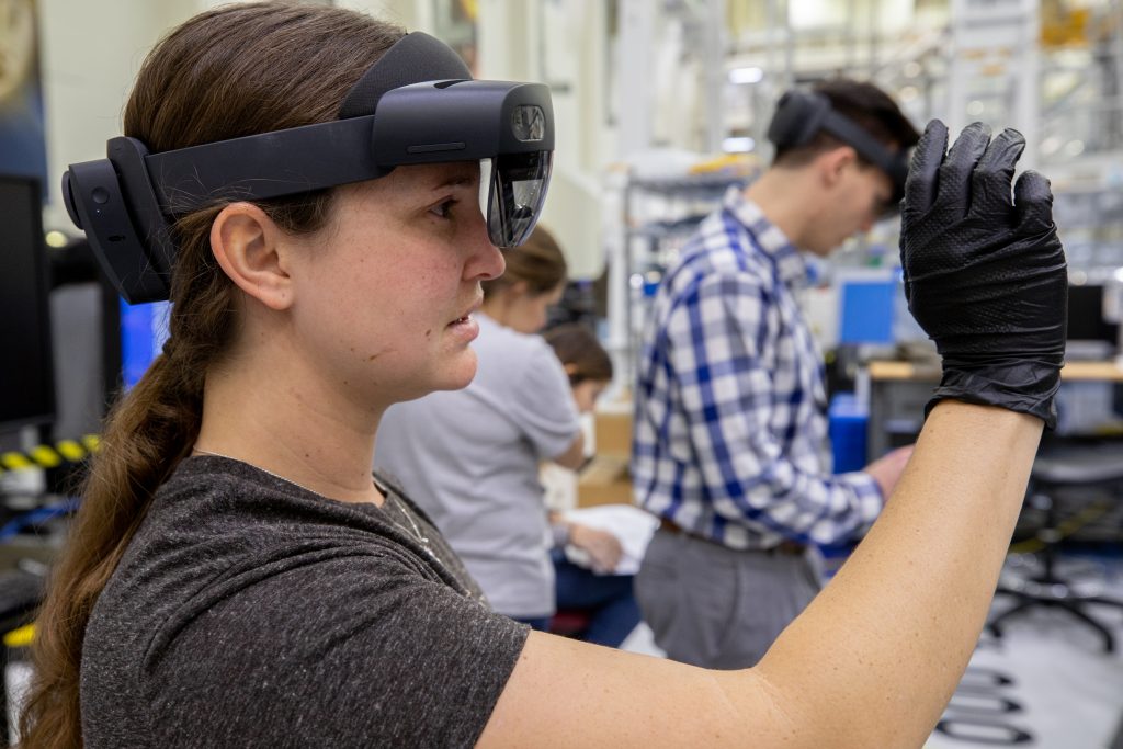 A technician wears a pair of augmented reality goggles to perform work on Orion hardware in the O&C high bay at Kennedy Space Center in Florida.