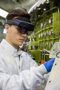 A technician wears a pair of augmented reality goggles to work on the crew module for NASA's Artemis II mission in the O&C high bay at NASA's Kennedy Space Center in Florida.