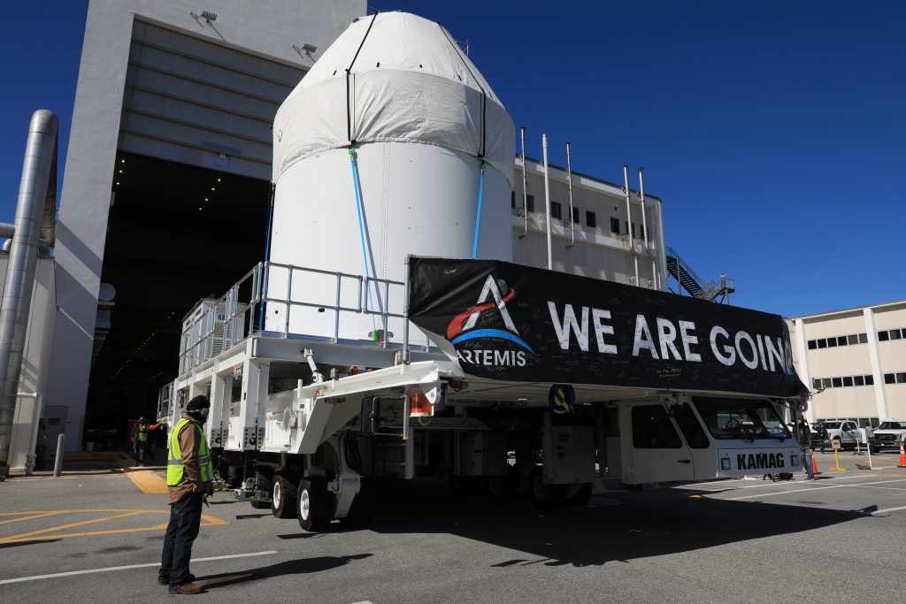 Orion is buttoned up and ready to march towards the Multi-Payload Processing Facility to begin ground processing by the Exploration Ground Systems and Jacobs teams ahead of the Artemis I launch. Shielded by a protective covering for transport, the spacecraft is depart its home at the Neil Armstrong Operations and Checkout Building at NASA's Kennedy Space Center in Florida on Jan. 16, 2021.