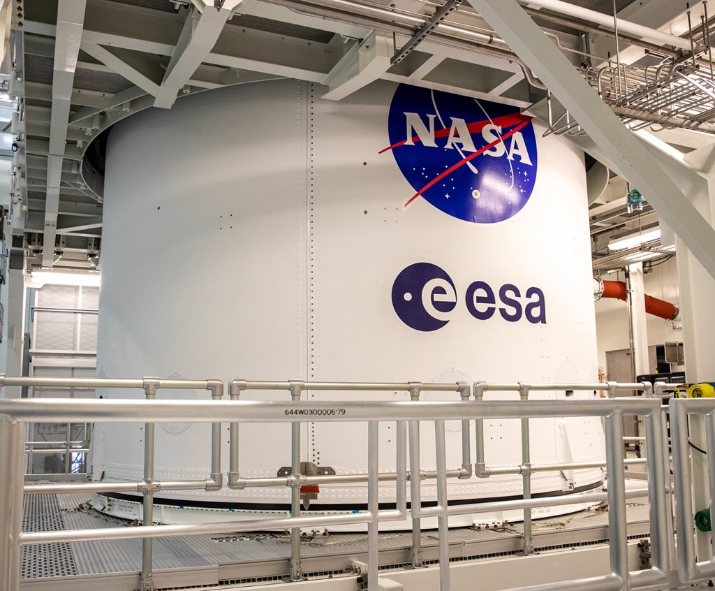 The NASA and ESA logos are visible on the Orion spacecraft adapter jettison fairing in the MPPF at Kennedy Space Center.